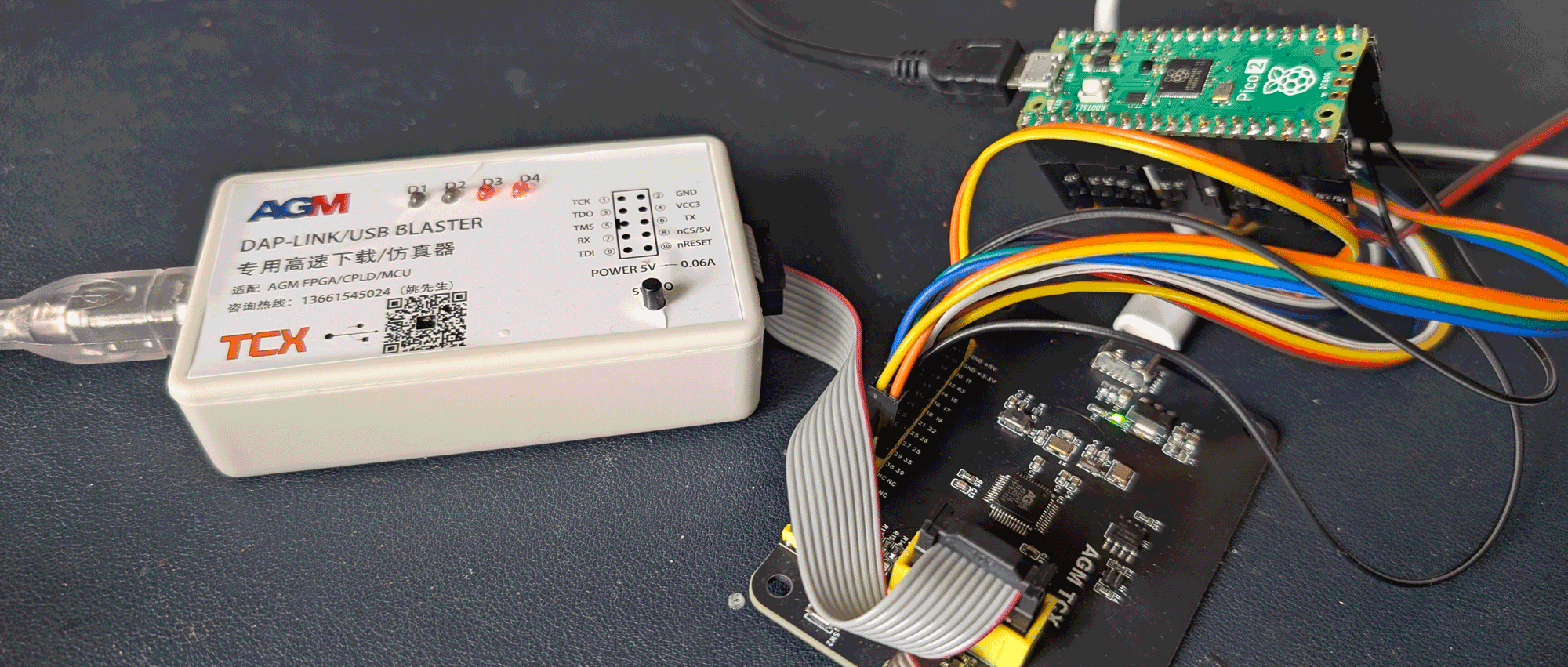 The AGM32 bus blaster, dev board, and a Pico 2 wired up as a horrible logic analyzer